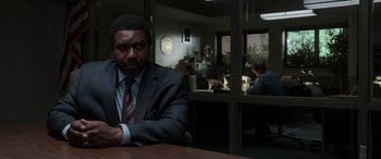 Movie still from “The Conjuring: The Devil Made Me Do It” (2021), directed by Michael Chaves – A man sitting at a table in front of a window; Medium shot, Low angle