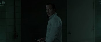 Movie still from “The Conjuring: The Devil Made Me Do It” (2021), directed by Michael Chaves – A man in a white dress shirt holding a wrench; Medium shot, Over the shoulder angle