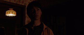 Movie still from “The Conjuring: The Devil Made Me Do It” (2021), directed by Michael Chaves – A man standing in the dark in a room lit by a flashlight; Close Up shot, Over the shoulder angle