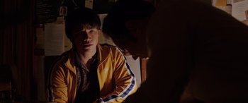 Movie still from “The Conjuring: The Devil Made Me Do It” (2021), directed by Michael Chaves – A man in a yellow jacket is looking at another man in a yellow jacket; Medium shot, Over the shoulder angle