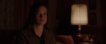 Movie still from “The Conjuring: The Devil Made Me Do It” (2021), directed by Michael Chaves – A young woman sitting in a dark room looking into the distance; Close Up shot, Over the shoulder angle