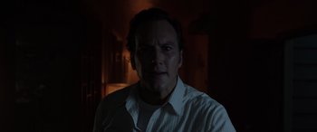 Movie still from “The Conjuring: The Devil Made Me Do It” (2021), directed by Michael Chaves – A man in a white shirt is in a dark room; Close Up shot, Low angle