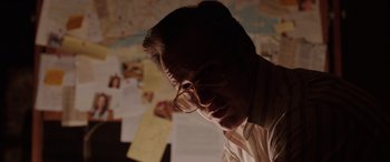 Movie still from “The Conjuring: The Devil Made Me Do It” (2021), directed by Michael Chaves – A man wearing glasses looking down at papers; Close Up shot, Over the shoulder angle