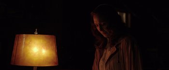 Movie still from “The Conjuring: The Devil Made Me Do It” (2021), directed by Michael Chaves – A woman standing in front of a lamp in the dark; Medium shot, Over the shoulder angle