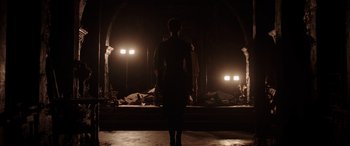 Movie still from “The Conjuring: The Devil Made Me Do It” (2021), directed by Michael Chaves – A man standing in front of two lights in a dark room; Wide shot, Low angle