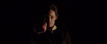 Movie still from “The Conjuring: The Devil Made Me Do It” (2021), directed by Michael Chaves – A woman is holding a wand in a dark room; Close Up shot, Low angle
