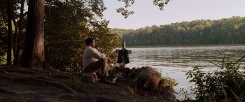 Movie still from “The Conjuring: The Devil Made Me Do It” (2021), directed by Michael Chaves – A man sitting next to a body of water; Wide shot, Over the shoulder angle