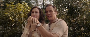 Movie still from “The Conjuring: The Devil Made Me Do It” (2021), directed by Michael Chaves – A man and a woman standing next to each other in front of trees; Close Up shot, High angle