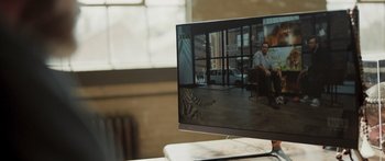 Movie still from “The Conservation Game” (2021), directed by Michael Webber – A television screen showing a man sitting on a chair in front of a tiger; Extreme Close Up shot, High angle