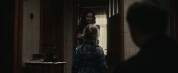 Movie still from “The Courier” (2020), directed by Dominic Cooke – A woman and a little girl standing in front of a window; Medium shot, Over the shoulder angle