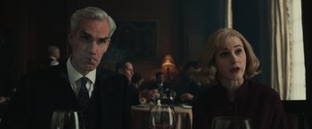 Movie still from “The Courier” (2020), directed by Dominic Cooke – A man smoking a cigarette in front of a wine glass; Medium shot, Low angle