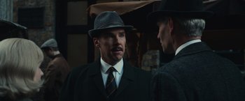 Movie still from “The Courier” (2020), directed by Dominic Cooke – A man wearing a hat and a tie; Close Up shot, Over the shoulder angle