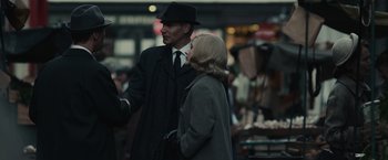 Movie still from “The Courier” (2020), directed by Dominic Cooke – A man and a woman wearing suits and hats; Medium shot, Over the shoulder angle