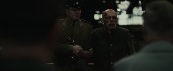 Movie still from “The Courier” (2020), directed by Dominic Cooke – A man in a black shirt and a man in a military uniform; Medium shot, Over the shoulder angle