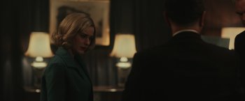 Movie still from “The Courier” (2020), directed by Dominic Cooke – A woman standing next to a man in a room; Medium shot, Over the shoulder angle