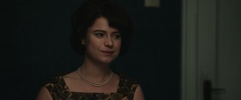 Movie still from “The Courier” (2020), directed by Dominic Cooke – A woman wearing a dress and a pearl necklace; Close Up shot, Over the shoulder angle