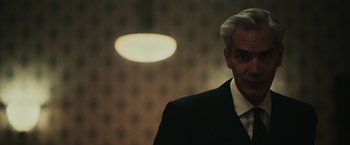 Movie still from “The Courier” (2020), directed by Dominic Cooke – A man in a suit and tie; Close Up shot, Over the shoulder angle