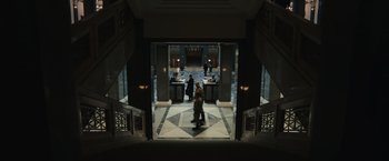 Movie still from “The Courier” (2020), directed by Dominic Cooke – Two people are standing in an entrance way of a building; Extreme Wide shot, Low angle