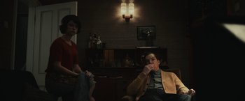 Movie still from “The Courier” (2020), directed by Dominic Cooke – A man and a woman sitting in a living room; Medium shot, Low angle