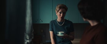 Movie still from “The Courier” (2020), directed by Dominic Cooke – A woman holding a coffee cup in her hand; Medium shot, Low angle