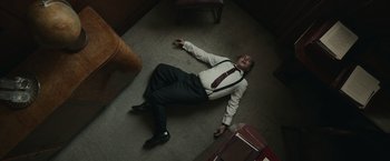 Movie still from “The Courier” (2020), directed by Dominic Cooke – A man is laying on the floor in a room; Medium shot, Overhead angle