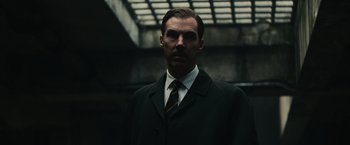 Movie still from “The Courier” (2020), directed by Dominic Cooke – A man wearing a suit and tie standing in front of a building; Close Up shot, Low angle