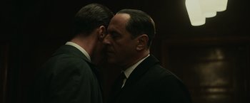 Movie still from “The Courier” (2020), directed by Dominic Cooke – A man in a suit kissing another man in a suit; Close Up shot, Over the shoulder angle