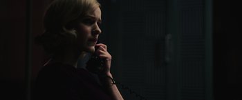 Movie still from “The Courier” (2020), directed by Dominic Cooke – A woman talking on a phone in a dark room; Close Up shot, Low angle