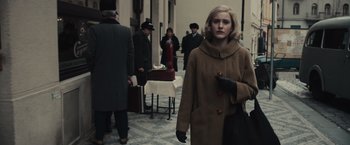 Movie still from “The Courier” (2020), directed by Dominic Cooke – A woman in a brown coat walking down a street; Medium shot, Over the shoulder angle