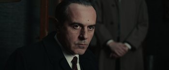 Movie still from “The Courier” (2020), directed by Dominic Cooke – A person wearing a suit and tie; Close Up shot, Low angle