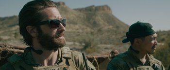 Movie still from “The Covenant” (2023), directed by Guy Ritchie – A person wearing sunglasses; Close Up shot, Over the shoulder angle