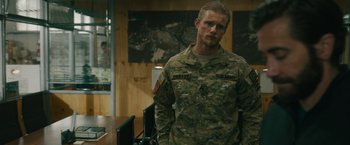 Movie still from “The Covenant” (2023), directed by Guy Ritchie – A man in military fatigues standing in front of a map; Medium shot, Over the shoulder angle