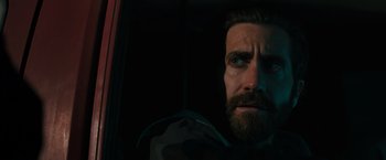 Movie still from “The Covenant” (2023), directed by Guy Ritchie – A person with a beard looking out a window; Close Up shot, Low angle