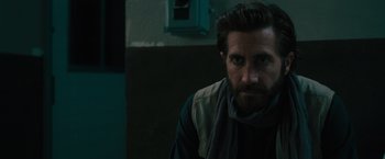 Movie still from “The Covenant” (2023), directed by Guy Ritchie – A person wearing a scarf; Close Up shot, Over the shoulder angle