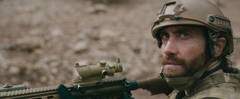 Movie still from “The Covenant” (2023), directed by Guy Ritchie – A man with a rifle and a rifle scope; Close Up shot, Over the shoulder angle