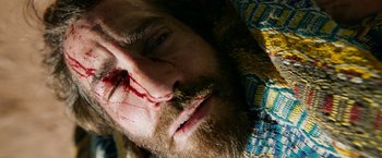 Movie still from “The Covenant” (2023), directed by Guy Ritchie – A person with a beard and a bloody nose; Close Up shot, Overhead angle