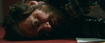 Movie still from “The Covenant” (2023), directed by Guy Ritchie – A person laying on the ground; Close Up shot, High angle