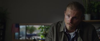 Movie still from “The Covenant” (2023), directed by Guy Ritchie – A person wearing a jacket and a tie; Close Up shot, Over the shoulder angle