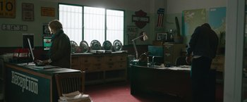 Movie still from “The Covenant” (2023), directed by Guy Ritchie – A room with a desk and a lot of wheels on the floor; Wide shot, High angle