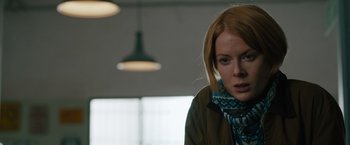 Movie still from “The Covenant” (2023), directed by Guy Ritchie – A woman in a brown jacket and a blue scarf; Close Up shot, Low angle