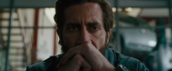 Movie still from “The Covenant” (2023), directed by Guy Ritchie – A person with his hands near his face; Close Up shot, Over the shoulder angle