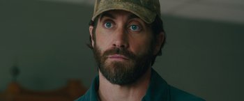 Movie still from “The Covenant” (2023), directed by Guy Ritchie – A person wearing a hat; Close Up shot, Over the shoulder angle