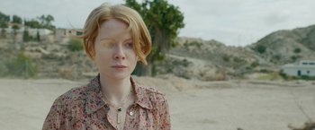 Movie still from “The Covenant” (2023), directed by Guy Ritchie – A woman with red hair wearing a floral shirt; Close Up shot, Over the shoulder angle