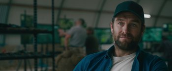 Movie still from “The Covenant” (2023), directed by Guy Ritchie – A person wearing a hat; Close Up shot, Over the shoulder angle