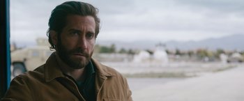 Movie still from “The Covenant” (2023), directed by Guy Ritchie – A person wearing a jacket; Close Up shot, Over the shoulder angle