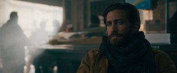 Movie still from “The Covenant” (2023), directed by Guy Ritchie – A person with a beard wearing a scarf; Close Up shot, Over the shoulder angle