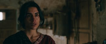 Movie still from “The Covenant” (2023), directed by Guy Ritchie – A person wearing a red shirt; Close Up shot, Over the shoulder angle