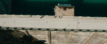 Movie still from “The Covenant” (2023), directed by Guy Ritchie – A bird sitting on top of a concrete structure; Extreme Wide shot, Overhead angle