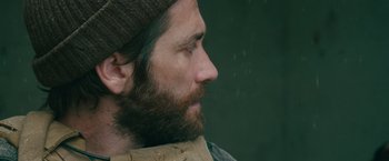 Movie still from “The Covenant” (2023), directed by Guy Ritchie – A person with a beard wearing a hat; Close Up shot, Over the shoulder angle