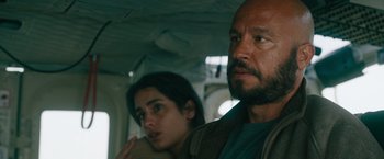 Movie still from “The Covenant” (2023), directed by Guy Ritchie – A man and a woman are looking at the camera; Close Up shot, Low angle